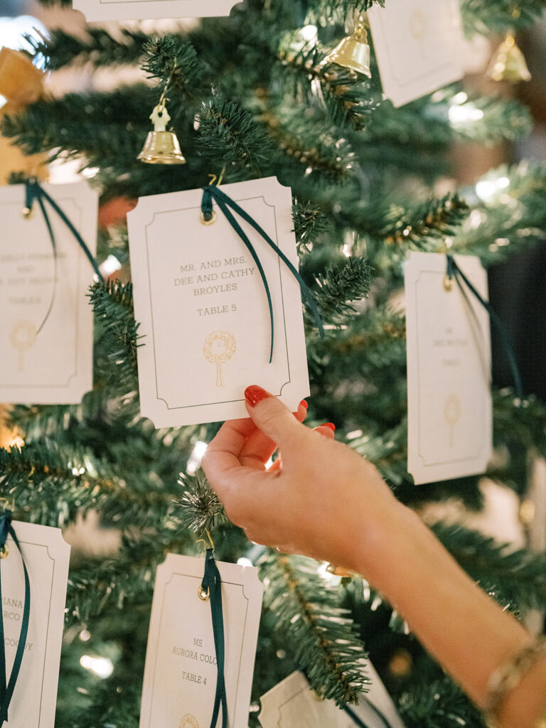 Escort cards hung on Christmas Trees during cocktail hour at Hotel Drover