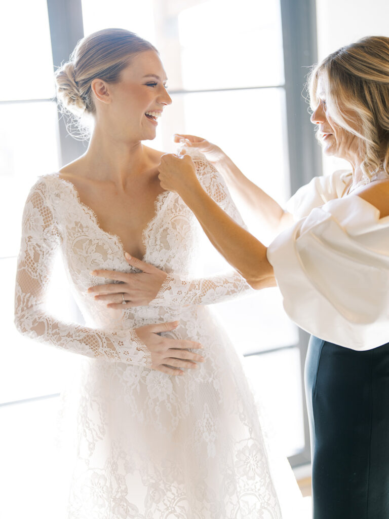 Mother of the Bride helps to put on the Brides dress at a Hotel Drover wedding