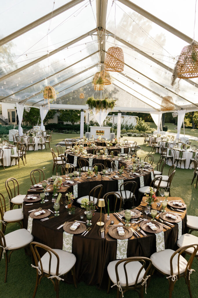 Oversized serpentine table in a tented wedding reception at Dallas Arboretum